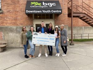 BGC Okanagan staff, standing in front of the downtown youth centre, holding a giant cheque with donor Dan Martell, who gave $50,000 to the Prevent Youth Homelessness campaign.